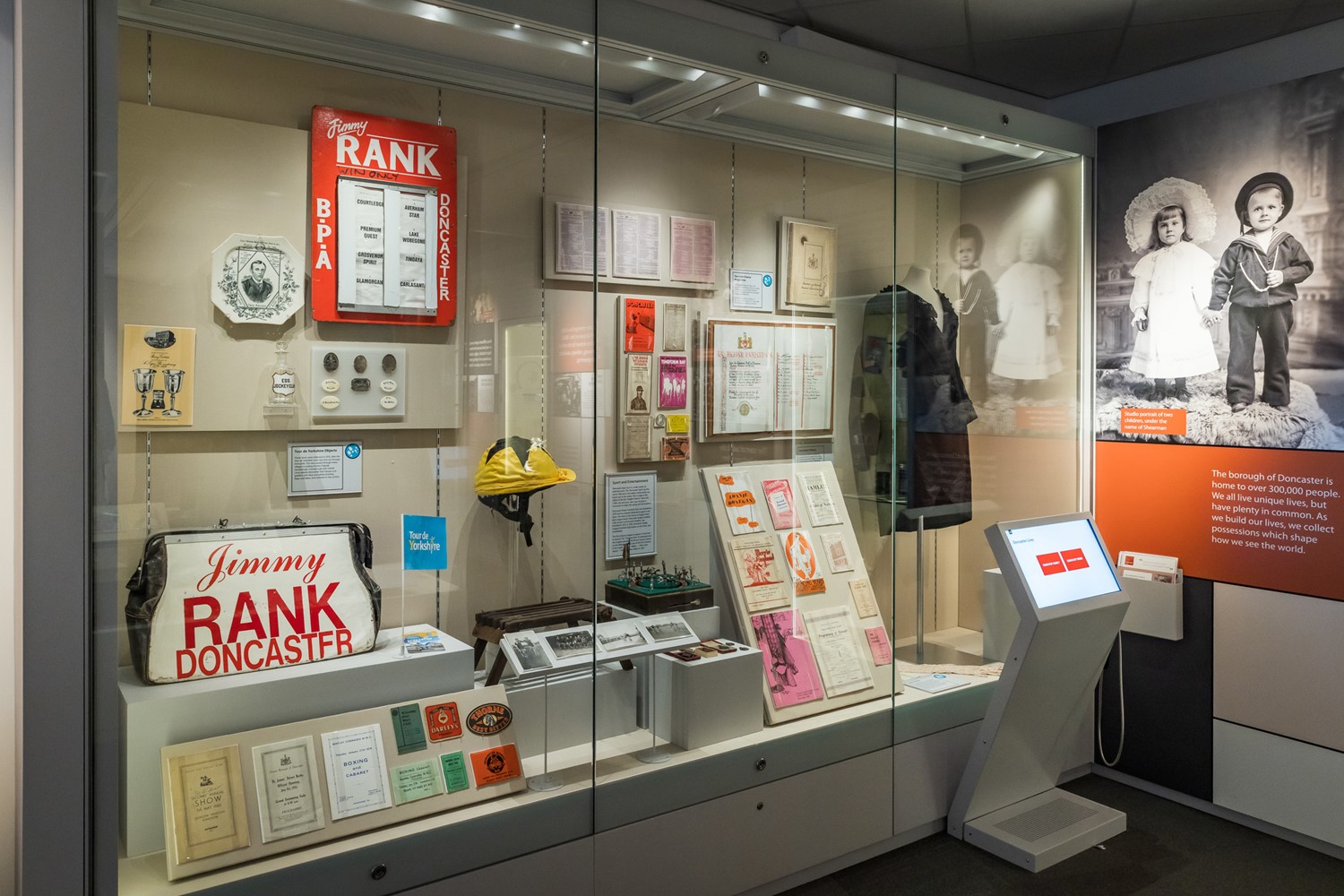 glass fronted museum display case at the Danum Gallery Library and Museum showing a range of sporting and entertainment related objects. 